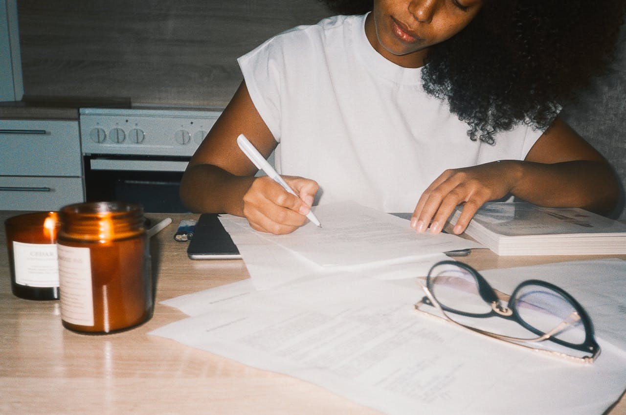 A woman writing on some documents