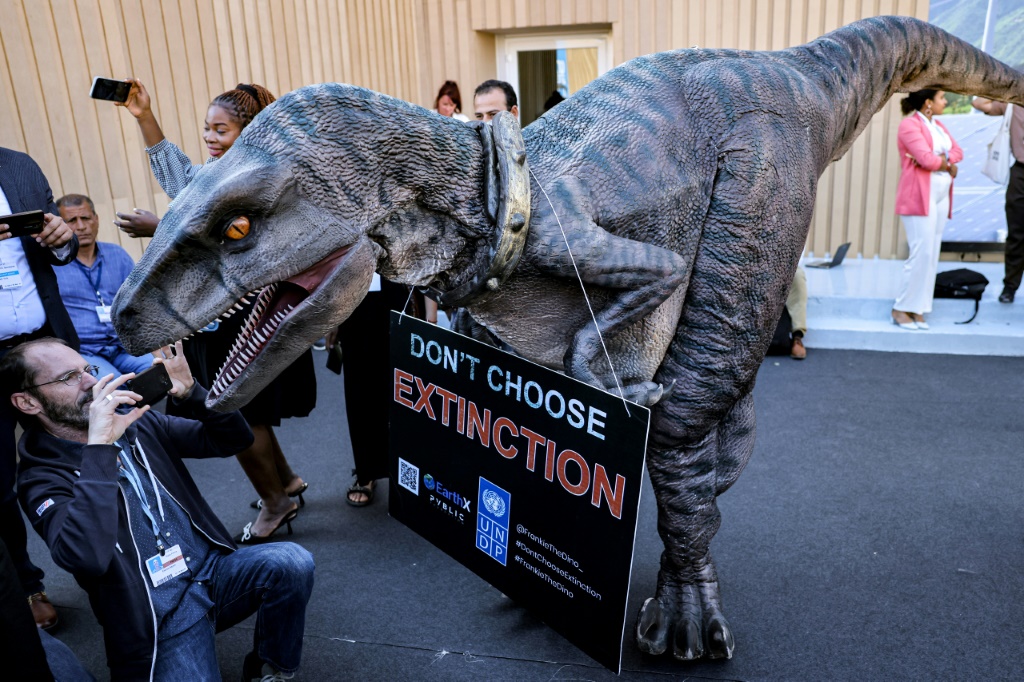 A dinosaur bears a message at COP27: 'Don't choose extinction'