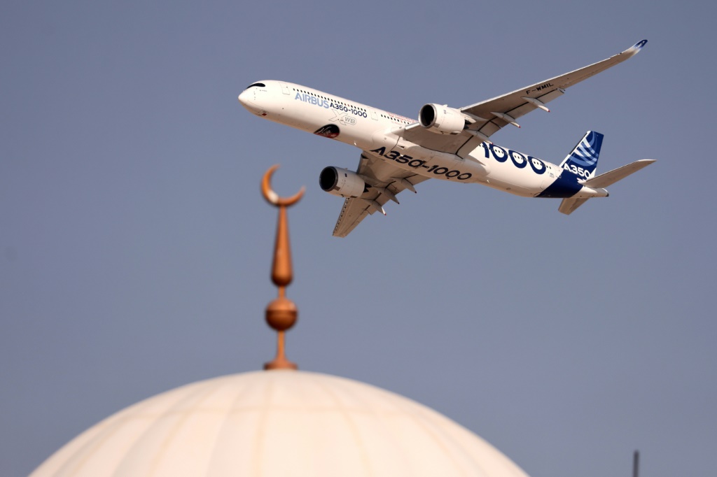 An Airbus A350-1000 aircraft flies above a mosque during the ongoing Dubai Airshow