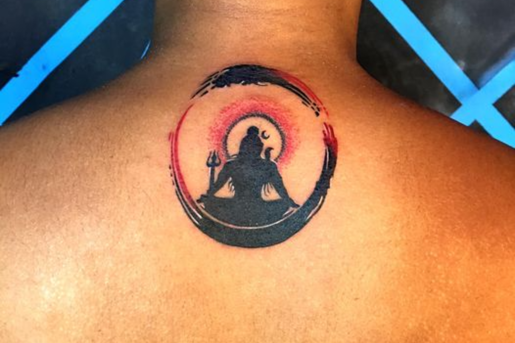 A man has a meditating woman tattoo on his upper back