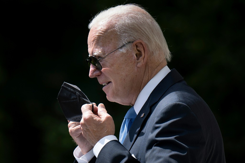 (FILES) In this file photo taken on July 27, 2022, US President Joe Biden removes his protective mask while arriving to deliver remarks in the Rose Garden of the White House in Washington, DC.US President Joe Biden on August 6, 2022, tested negative for Covid-19, days after coming down with a second bout of the illness.