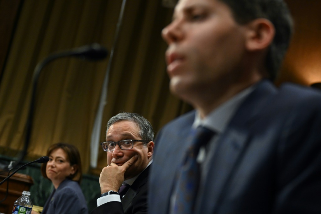 Christina Montgomery, Chief Privacy and Trust Officer at IBM, and Gary Marcus, Professor Emeritus at New York University, look on as Samuel Altman, CEO of OpenAI, testifies during a Senate Judiciary panel