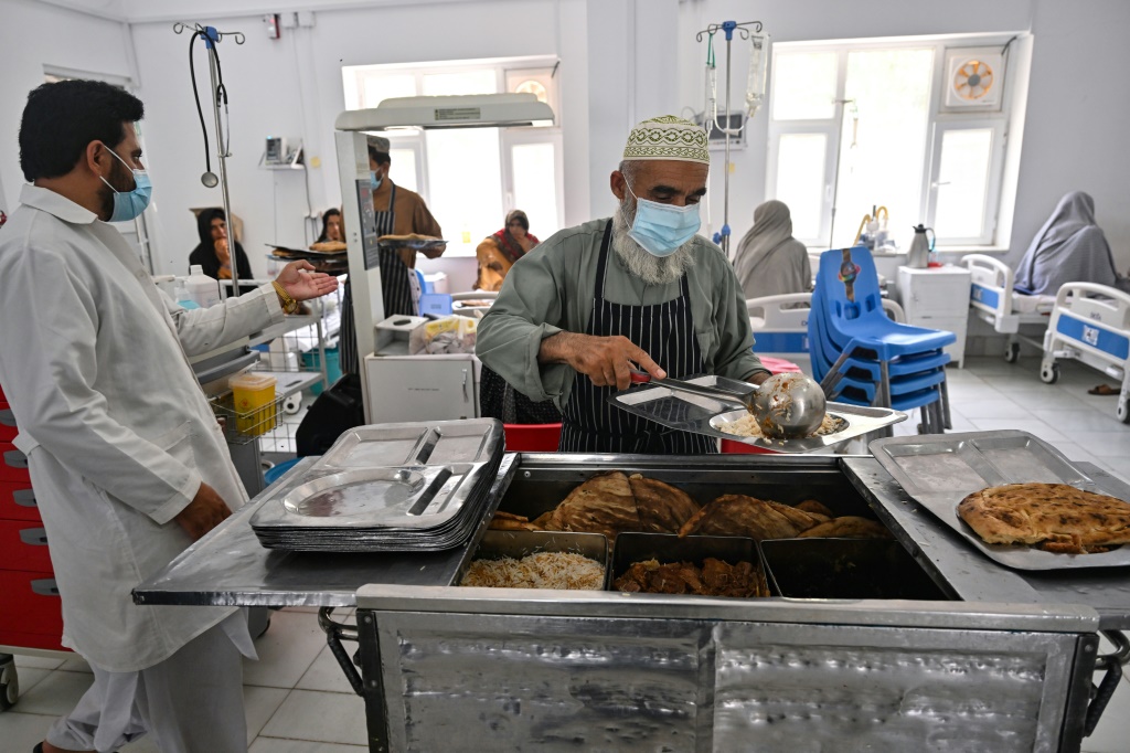 A staff member serves food to the doctors and nurses working in the critical care section of the malnutrition ward at Boost Hospital