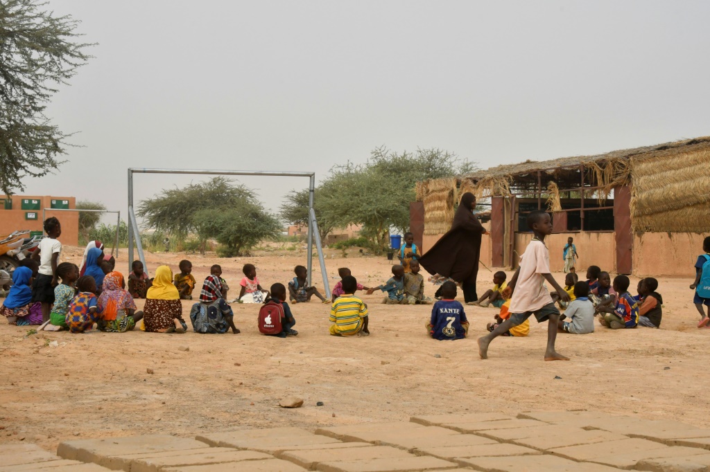 Time for play: A teacher and her pupils in the yard of a school set up for displaced children