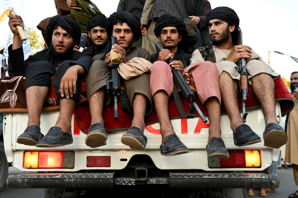 Taliban fighters in the back of a pick-up truck in Kabul, where a suicide bomber killed at least two people in an attack outside the Russian embassy