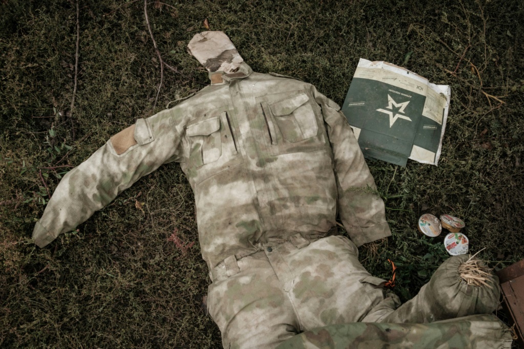 A stuffed Russian army uniform lies on the gound near a suspected mass grave in Kozacha Lopan in eastern Ukraine