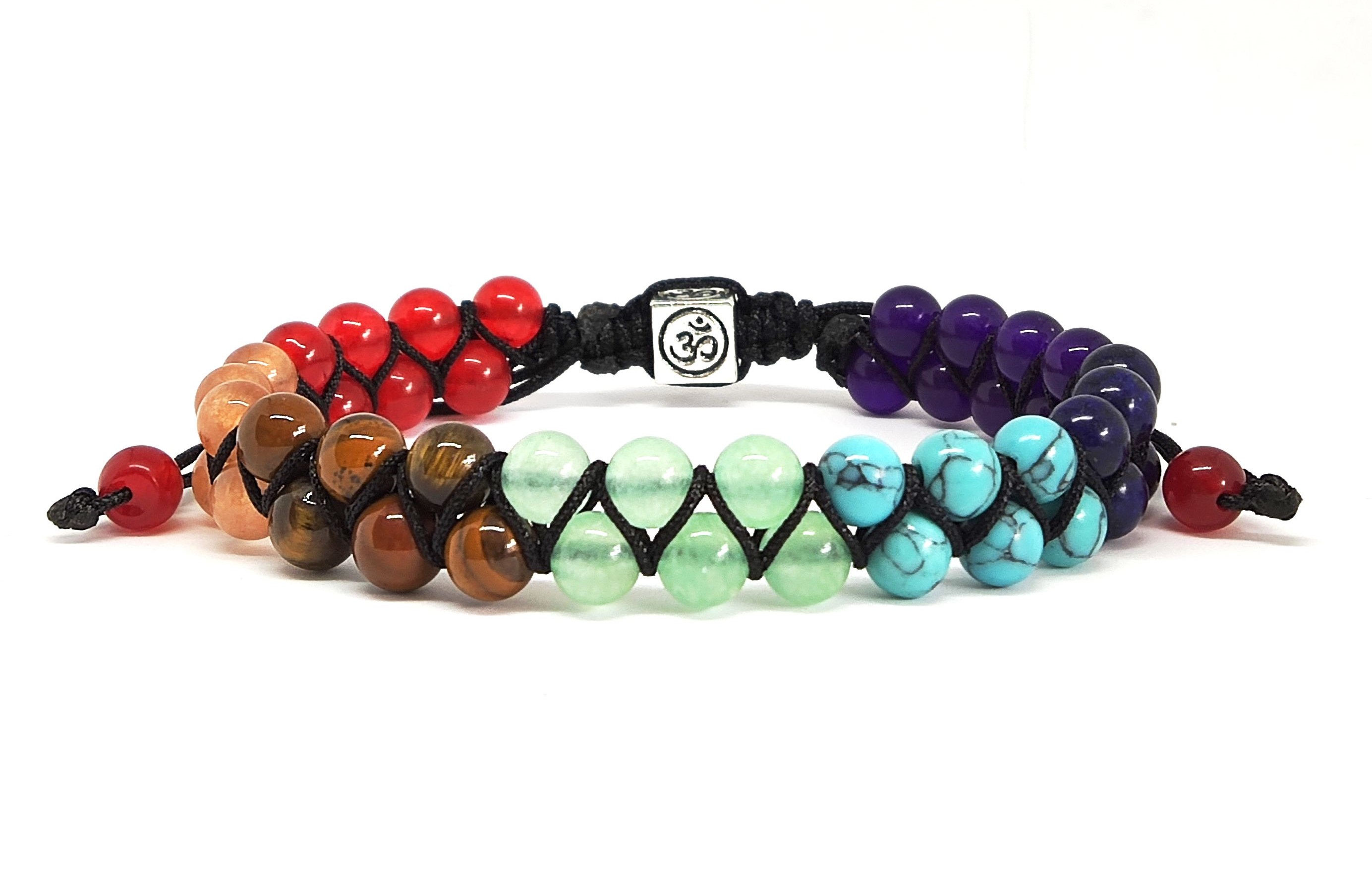 A multicoloured chakra bracelet rests against a plain background