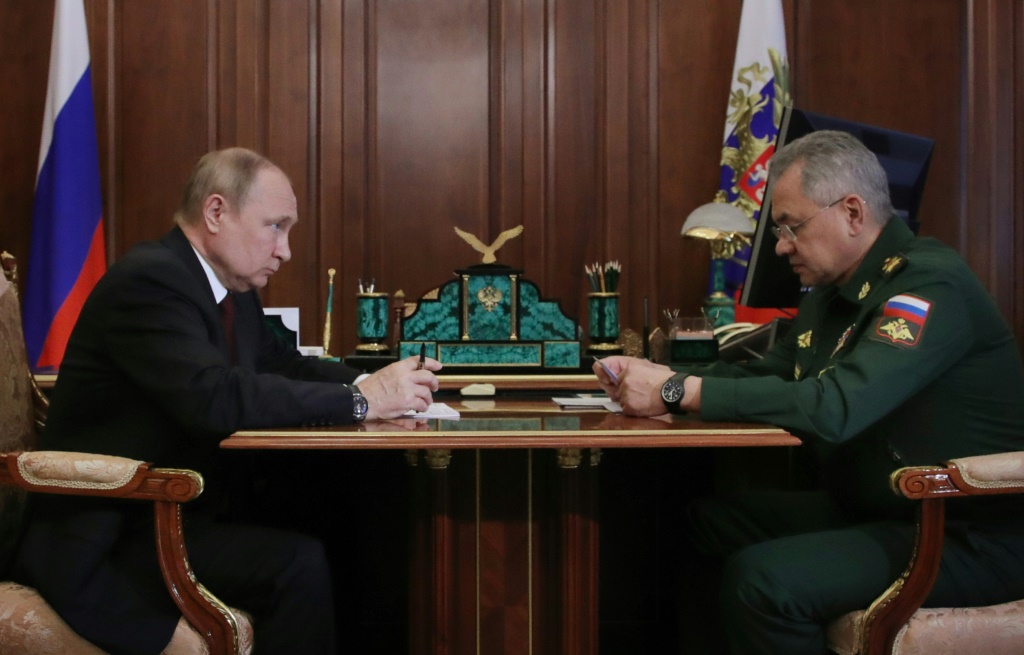 Russian President Vladimir Putin sits with  Defence Minister Sergei Shoigu at the Kremlin