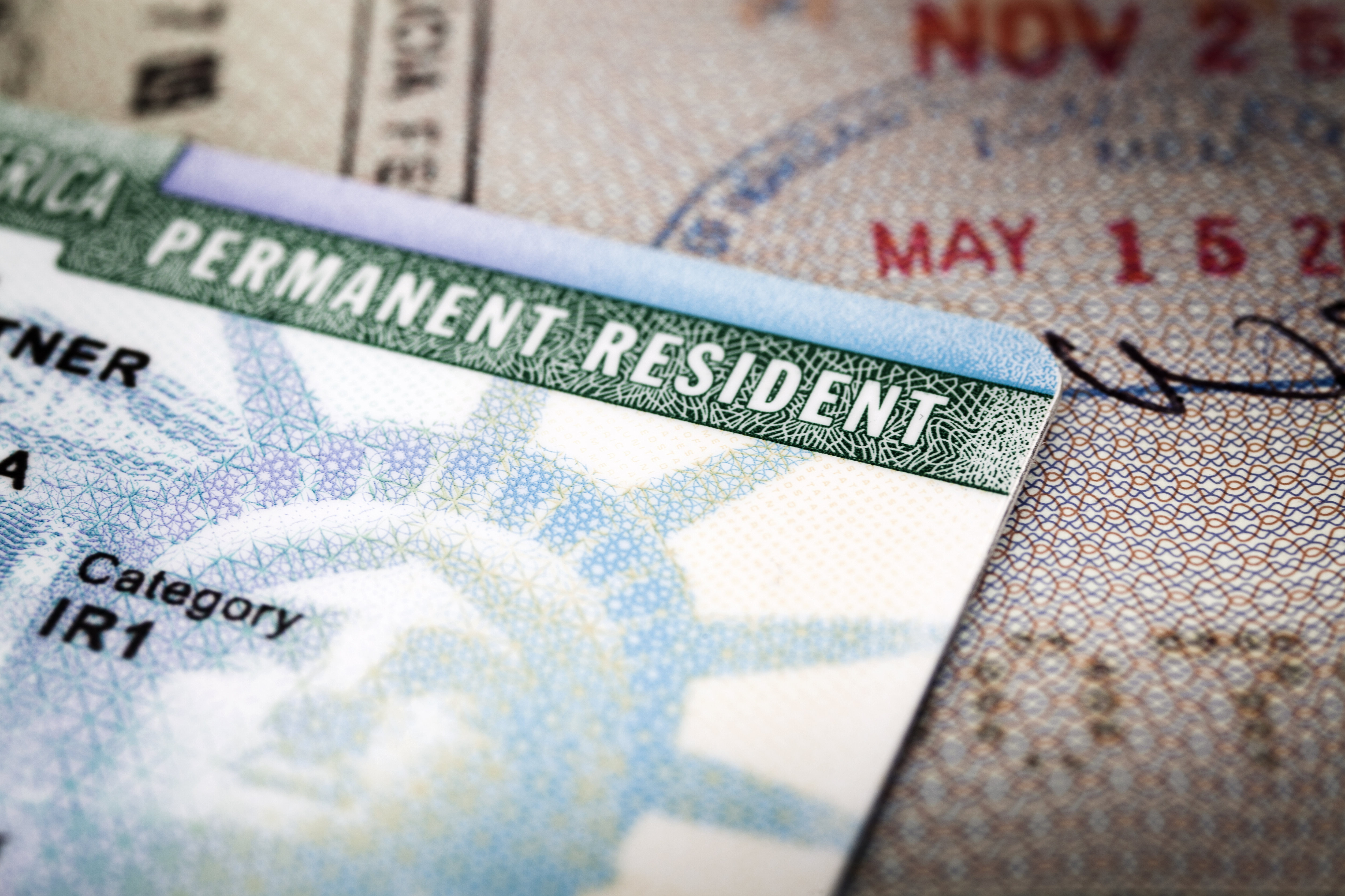A Green Card lying on an open passport