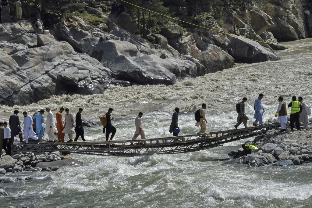 A vehicle bridge across the Swat River was destroyed by a flash flood, and now the only way across is by a rickety makeshift footbridge.
