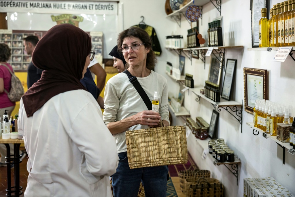A tourist buys a bottle of argan oil -- the cooperative's younger workers prefer work in the gift shop