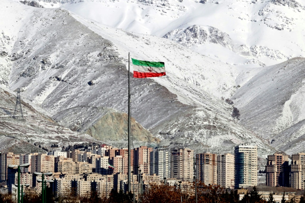 A view of a giant Iranian flag in the capital Tehran with the snow-covered Alborz mountain range in the background on January 18, 2022