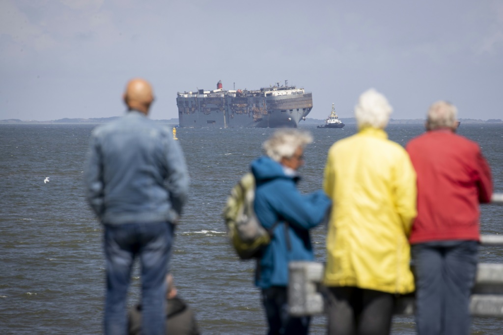 Dozens of people turned out to watch the ship being towed into port