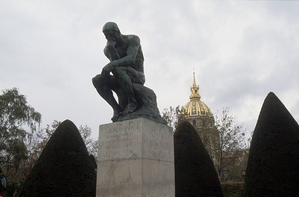 Auguste Rodin's sculpture The Thinker sits in a garden at the Musée Rodin in Paris, France.