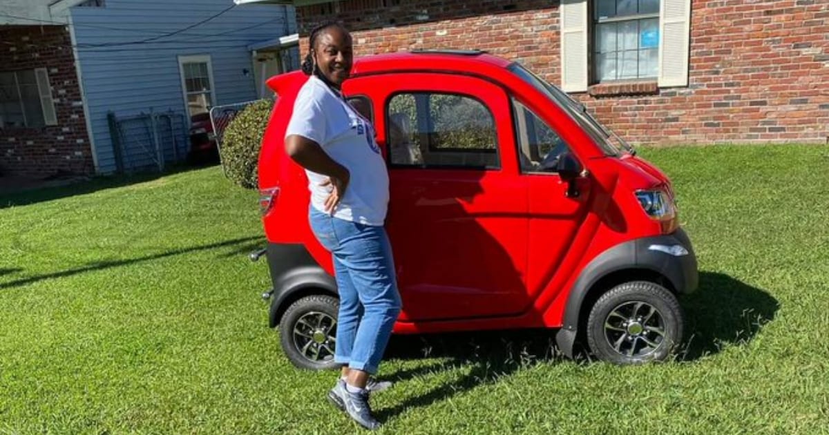 Woman shows of her tiny red car