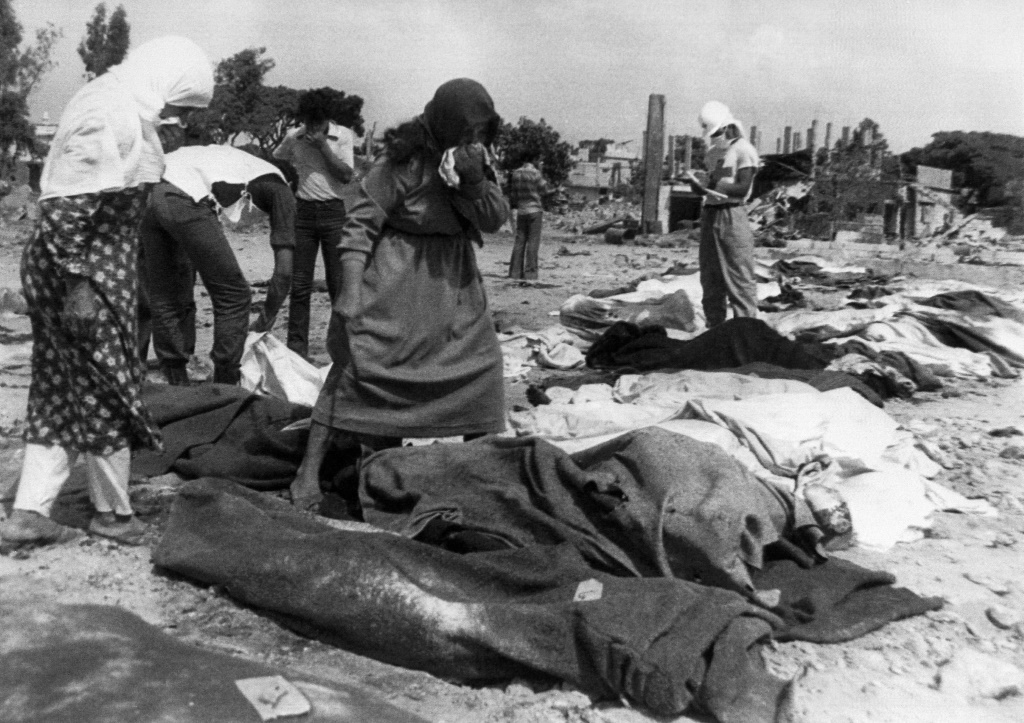 In this file photo taken on September 21, 1982, women search for their relatives among corpses following the massacre by Israeli-backed Christian militiamen in Sabra and Shatila on the outskirts of Lebanon's capital Beirut