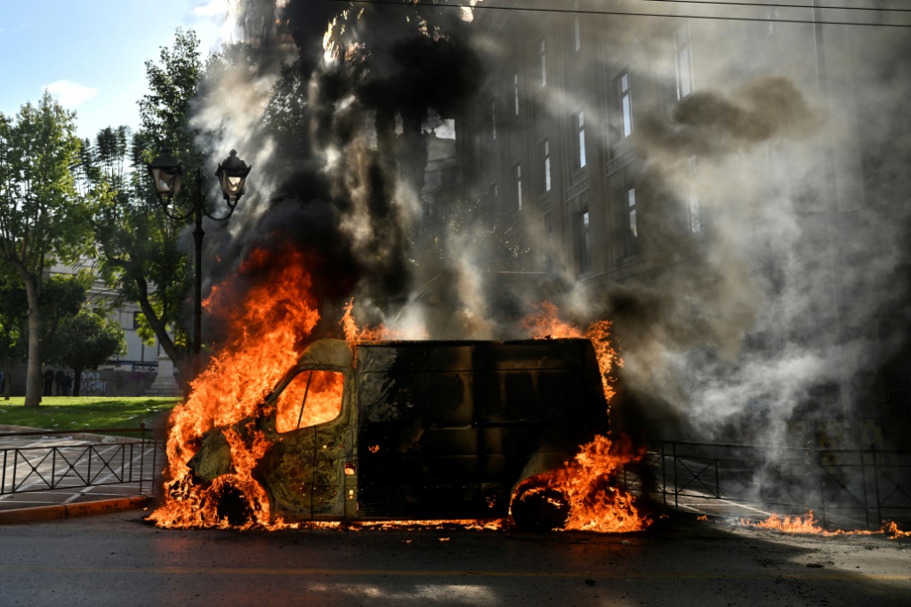 A van was torched during protests in Athens over the country's deadliest rail crash
