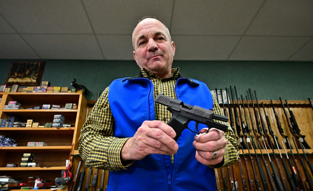 Patrick Jones, an elected official in Shasta County, California, displays wares in his gunshop