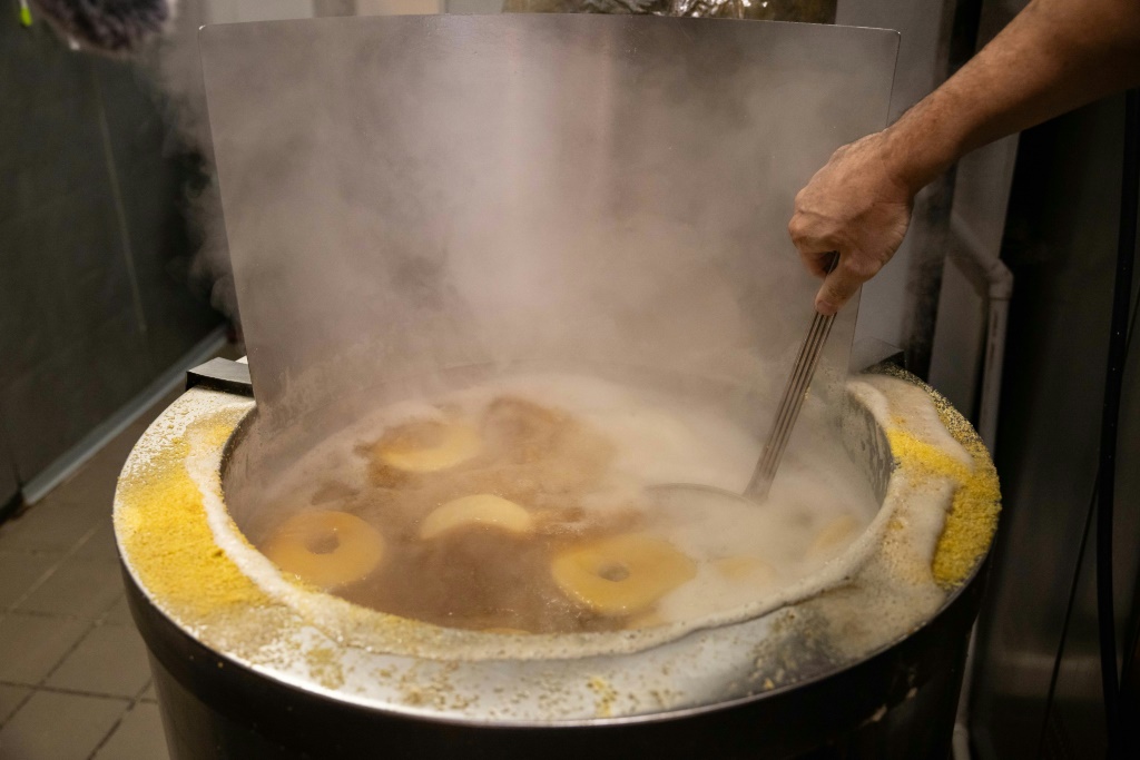 Andrew Martinez boils bagel dough before the daily opening of his store in the New York borough of Harlem
