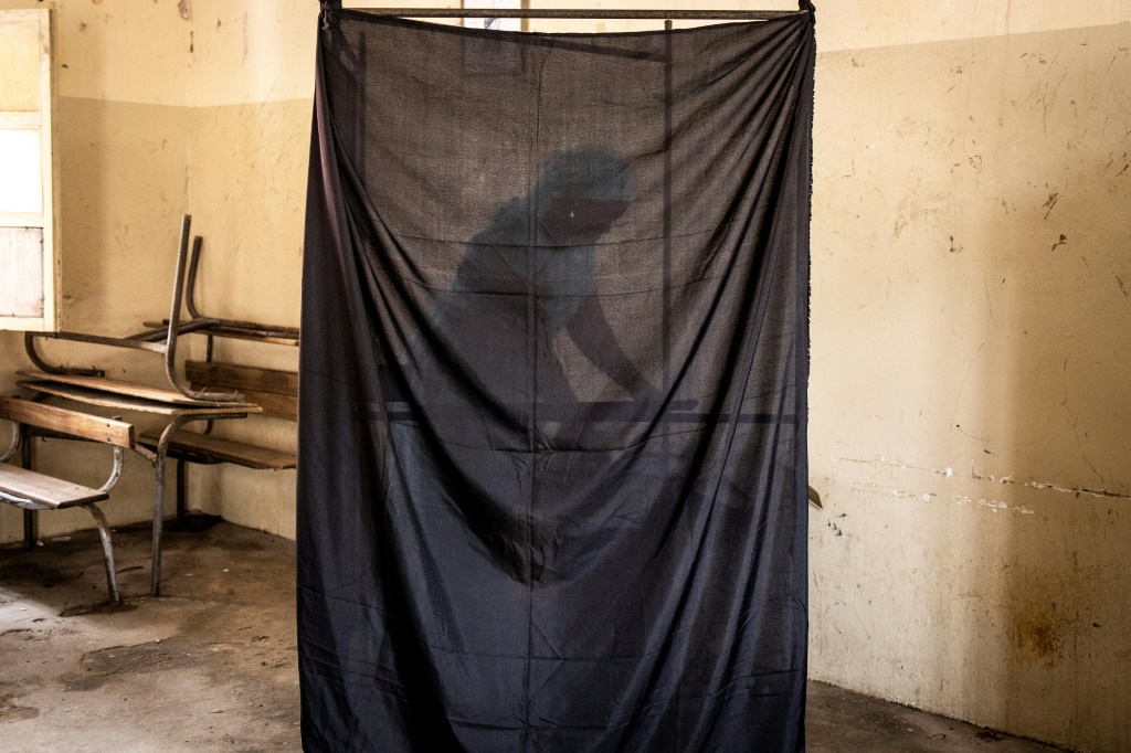 A woman chooses her voting card in Dakar on July 31