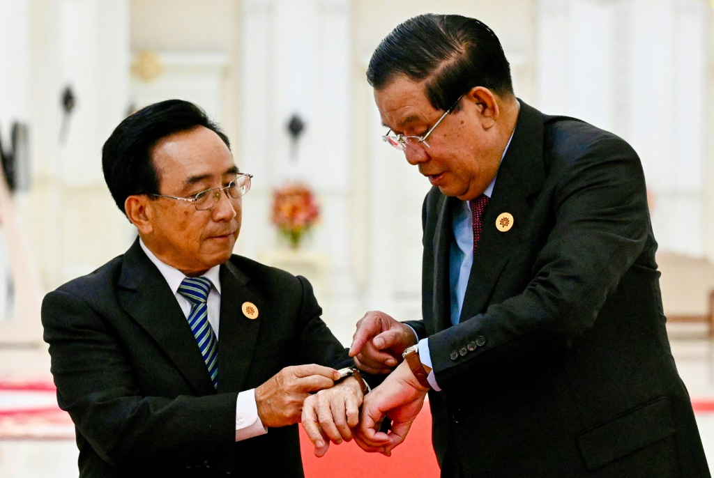 Cambodia's Prime Minister Hun Sen (R) is gifting leaders like Laos' Prime Minister Phankham Viphavanh locally made watches