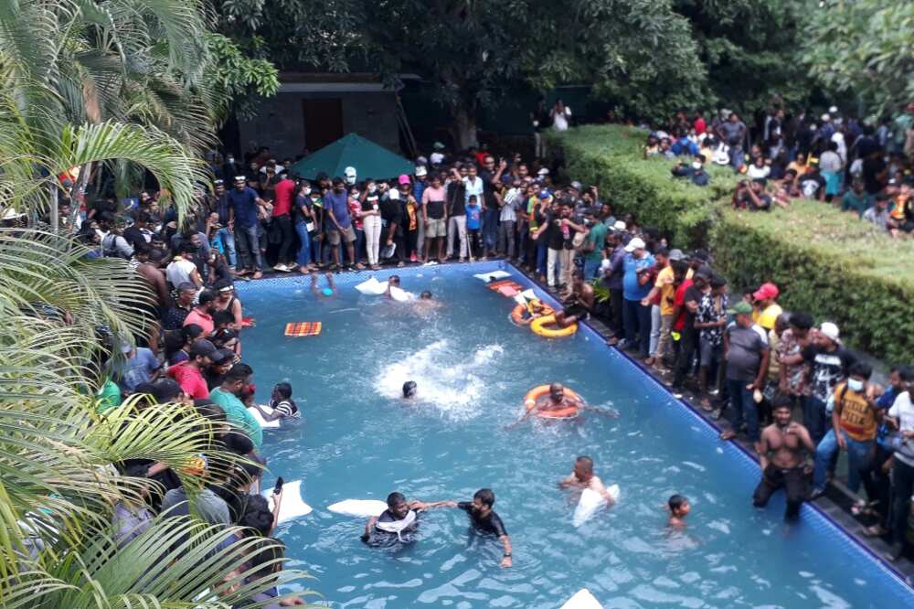 Sri Lankan protesters enjoy a swim after storming the official residence of President Gotabaya Rajapaksa Saturday